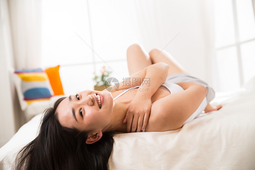 东亚亚洲户内青年女人在卧室的床上图片