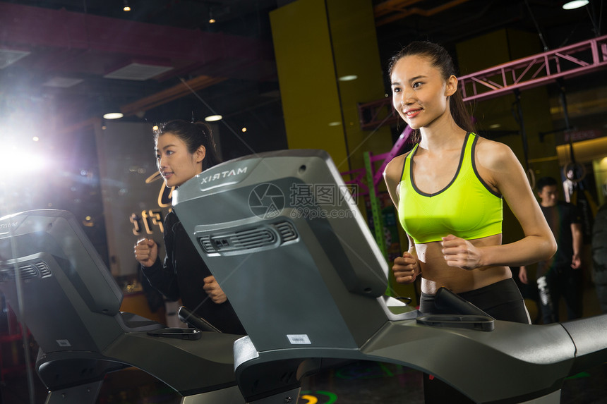 体育器材两个人塑身青年女人在健身房健身图片