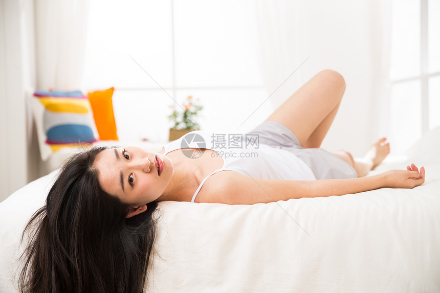 水平构图愉悦健康生活方式青年女人在卧室的床上图片