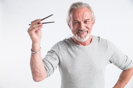 老年摄影快乐水平构图摄影老年男人拿着筷子背景