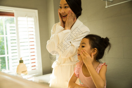 家庭生活独生子家庭可爱的小女孩和妈妈在卫生间里洗漱图片