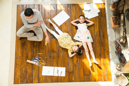 坐在笔上的女孩幸福家庭躺在地板上背景