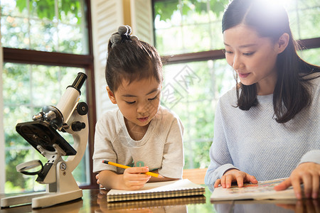 光学显微镜两个人家庭作业独生子家庭妈妈辅导女儿做作业背景