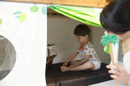 寄宿学校户内儿童房可爱的小男孩和指导教师在游戏室玩耍图片