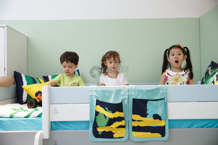 水平构图可爱友谊欢乐的儿童在床上玩耍图片