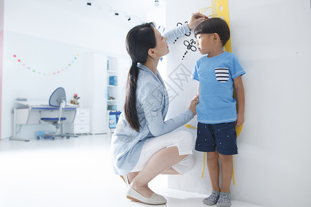 儿童创意画家庭生活两个人住宅房间妈妈在为小男孩测量身高背景
