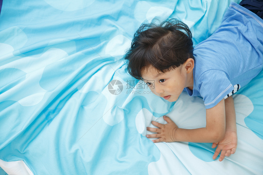健康的学龄前儿童棉被可爱的小男孩在床上玩耍图片
