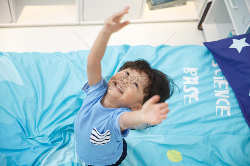 蓝色水平构图成长可爱的小男孩在床上玩耍图片