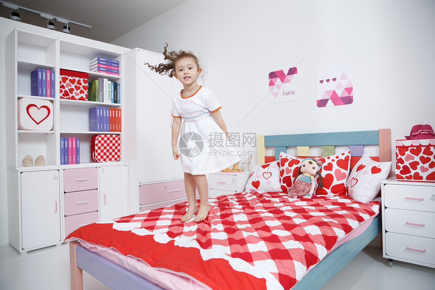 华贵住宅内部幸福可爱的小女孩在卧室玩耍图片