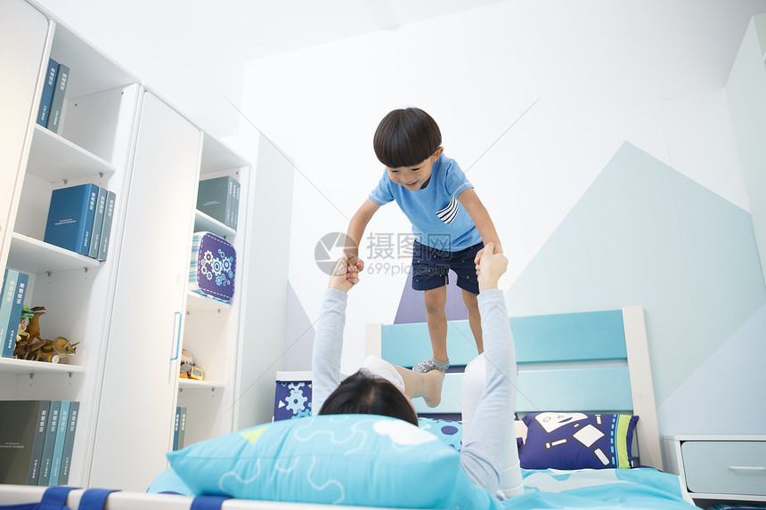 休闲玩具纯洁可爱的小男孩和妈妈在卧室玩耍图片