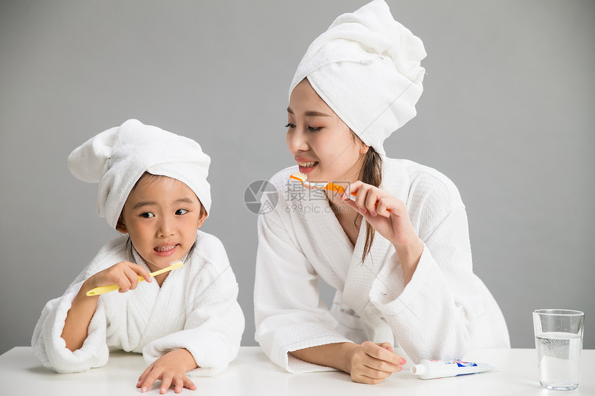 水平构图休闲装浴巾穿着浴袍的母女刷牙图片