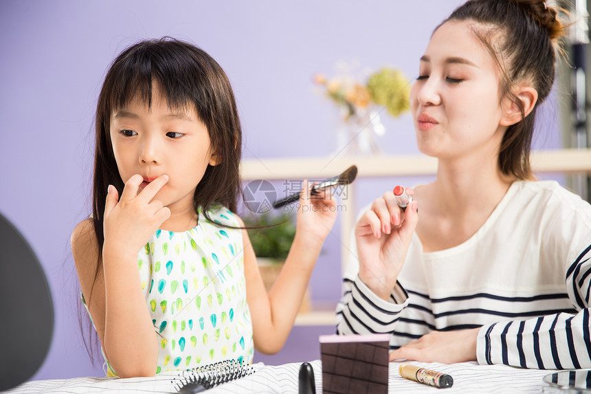 青年女人可爱的亲情妈妈与女儿在化妆图片