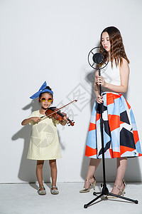 幸福裙子活力小女孩和妈妈拉小提琴图片素材