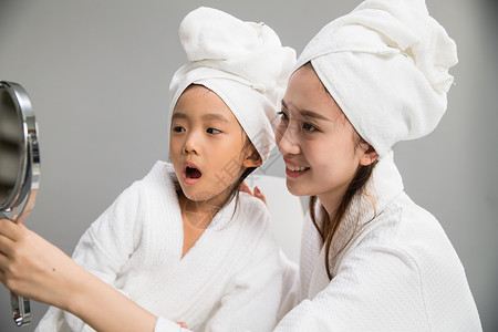 活力20多岁浴巾穿着浴袍的母女照镜子图片