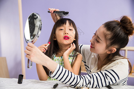 时尚可爱的玩耍妈妈与女儿在化妆图片