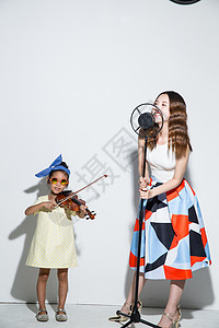 时尚休闲装欢乐小女孩和妈妈拉小提琴图片