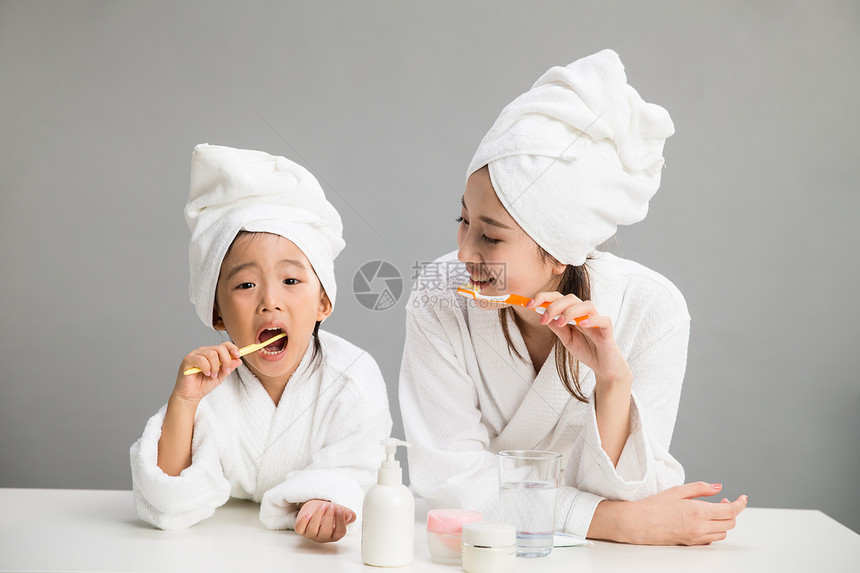 优雅20多岁东方人穿着浴袍的母女刷牙图片