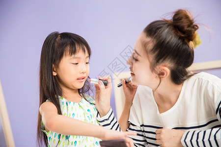 儿童化妆品彩色图片母亲独生子家庭妈妈与女儿在化妆背景