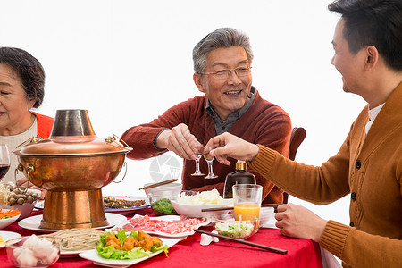 端着羊肉男人父子俩吃年夜饭喝酒背景