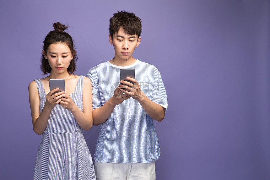 水平构图青年伴侣生气各自玩手机的青年情侣图片