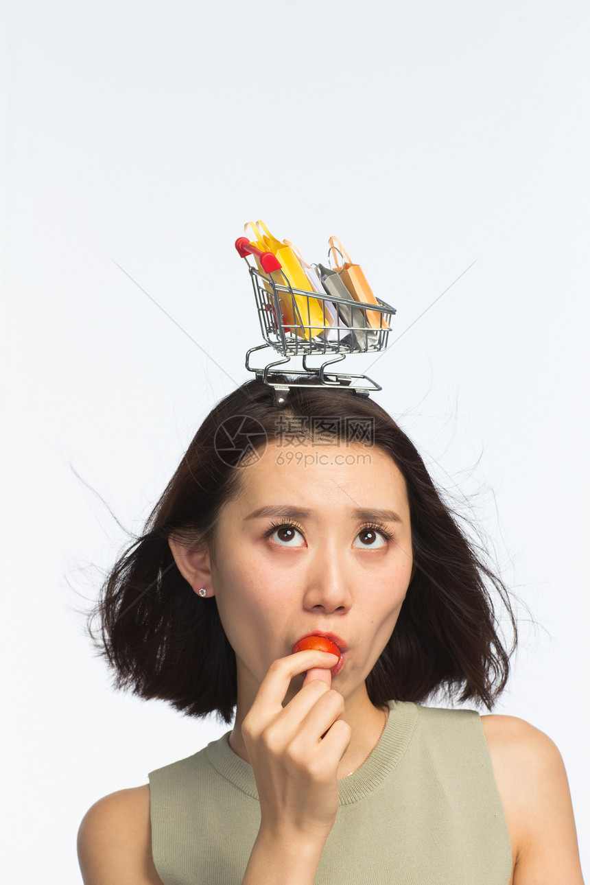 垂直构图亚洲自由年轻女孩头顶购物车图片