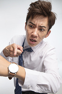 调整状态最终期限衬衫领带手表戴着腕表的商务青年男人背景