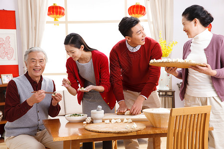 男人坐着成年人快乐家庭过新年包饺子图片