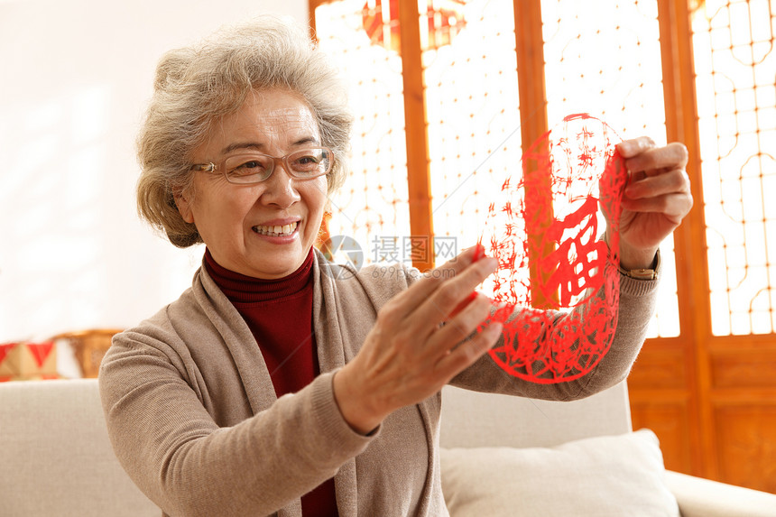 亚洲人东方人住宅房间老年人过年贴窗花图片