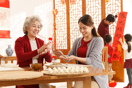吃饺子的小孩6岁到7岁20多岁毛衣幸福家庭过年包饺子背景