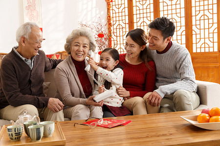 独生子家庭坐着五个人幸福家庭过年打电话兴奋高清图片素材