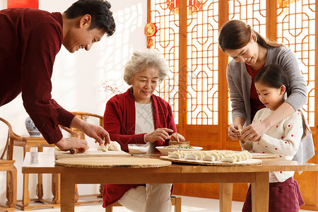 温馨白昼传统节日幸福家庭过年包饺子图片