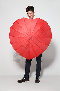 一把打开的雨伞遮挡垂直构图正装青年男人拿着心形红雨伞背景