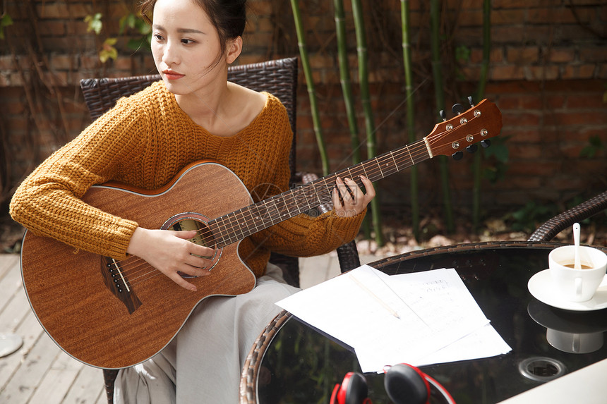 田园风光东亚户外年轻女人弹吉他图片