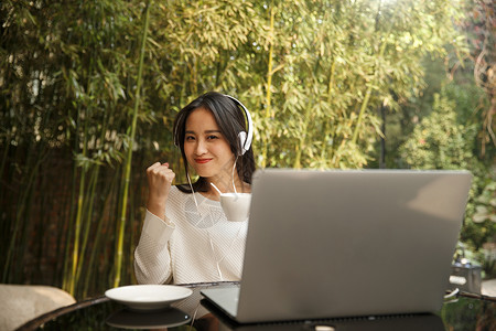 青年女性使用电脑听音乐青年女人音乐互联网年轻女人使用笔记本电脑背景