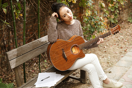 亚洲业余爱好时尚年轻女人弹吉他图片