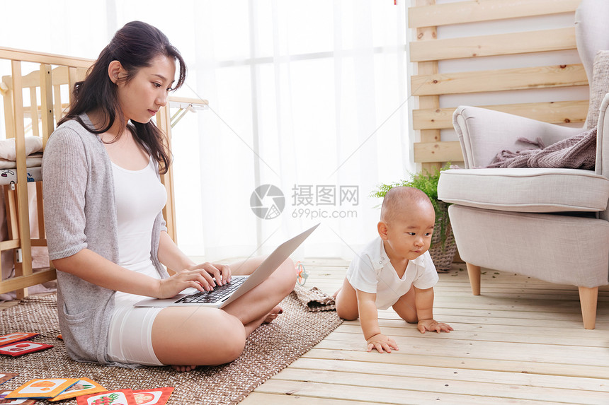 互联网笔记本电脑两个人年轻妈妈在家边看孩子边使用电脑图片