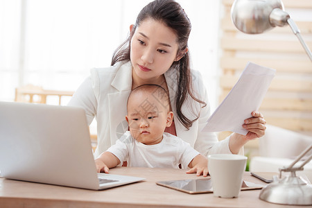 纸母子男婴年轻妈妈抱着孩子在家办公高清图片