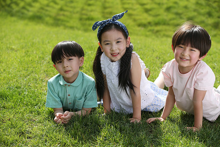 玩耍3岁到4岁休闲活动快乐的孩子趴在草地上亚洲人高清图片素材