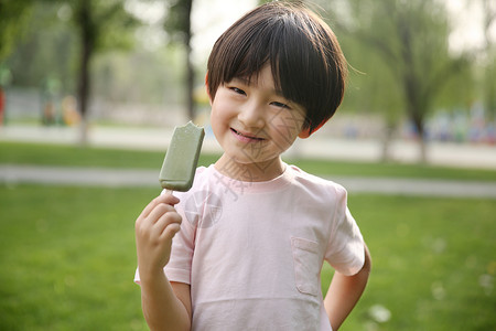 可爱的白昼亚洲人小男孩吃冰棍图片