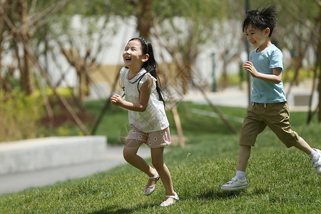 游乐场户外休闲装儿童在草地上玩耍友谊高清图片素材