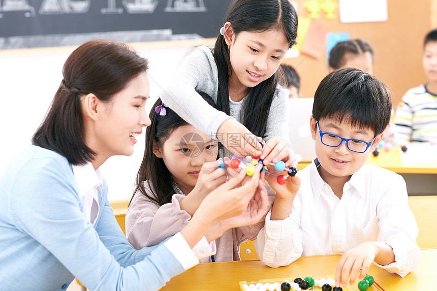 指导女教师和小学生在教室里上课图片