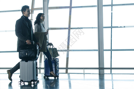 情侣步行商务男女在机场步行背景