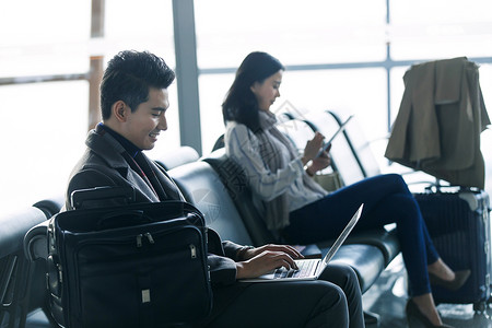 航空业东亚笔记本电脑商务男女在候机大厅图片