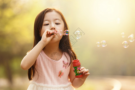 透明泡泡粉色彩色图片5到6岁可爱的女孩在户外背景