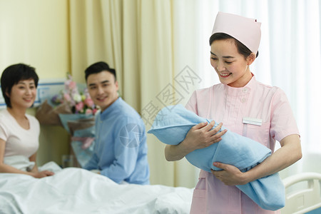 男人协助产科护士和新生儿的父母高清图片