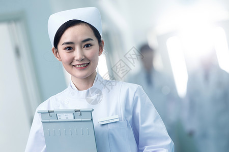 胸卡露齿一笑制服信心年轻的女护士在医院走廊背景