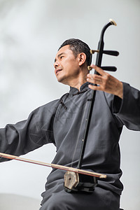 东方人自信民族乐器男艺术家在拉二胡图片