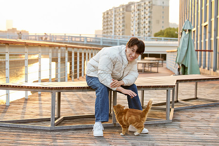 猫到冬天素材秋冬男性室外与猫咪互动背景