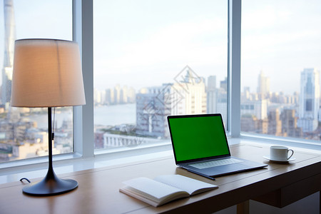 窗台边桌子上的电脑和笔记本高清图片