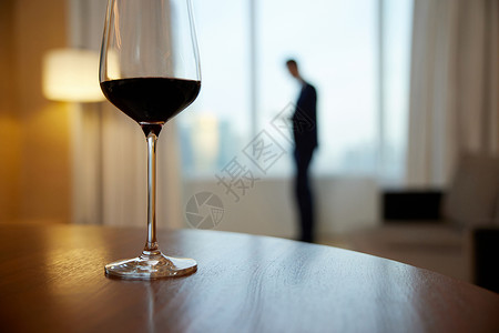 成功人士剪影桌子上的红酒和男士剪影背景